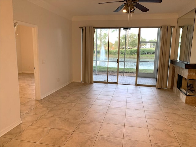 empty room featuring ceiling fan, light tile patterned floors, and a tiled fireplace