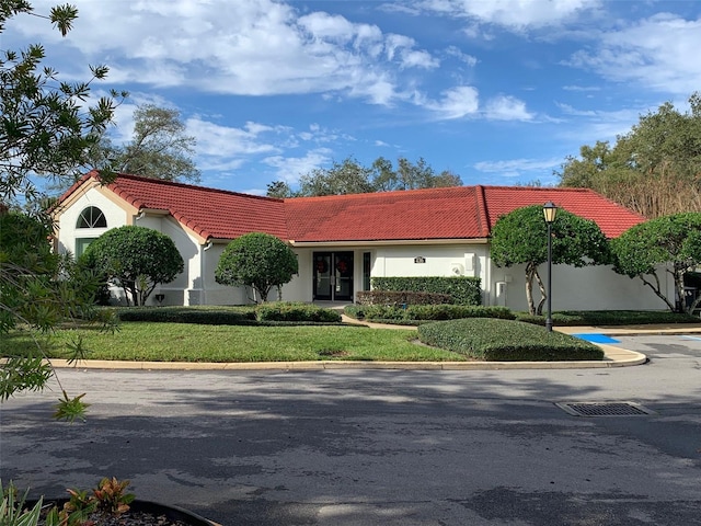 mediterranean / spanish home with a front lawn