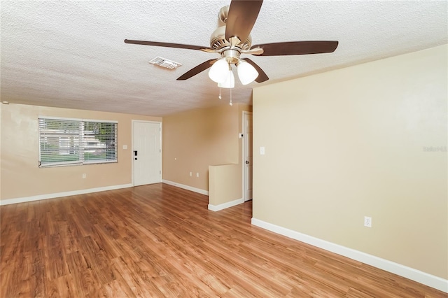 empty room featuring ceiling fan, light hardwood / wood-style flooring, and a textured ceiling