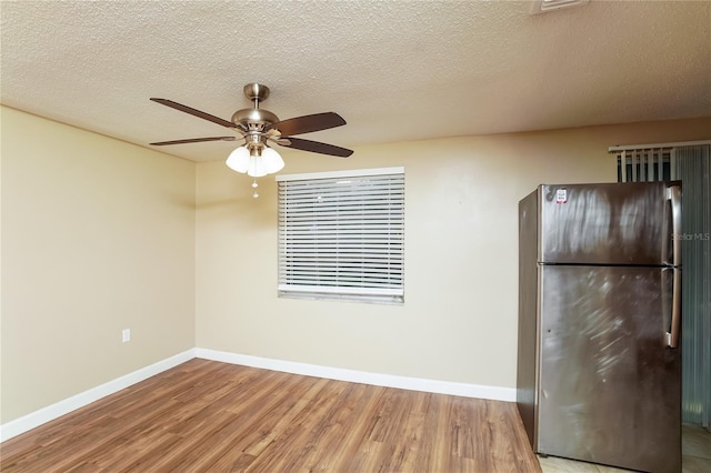 kitchen with stainless steel fridge, a textured ceiling, ceiling fan, and hardwood / wood-style floors