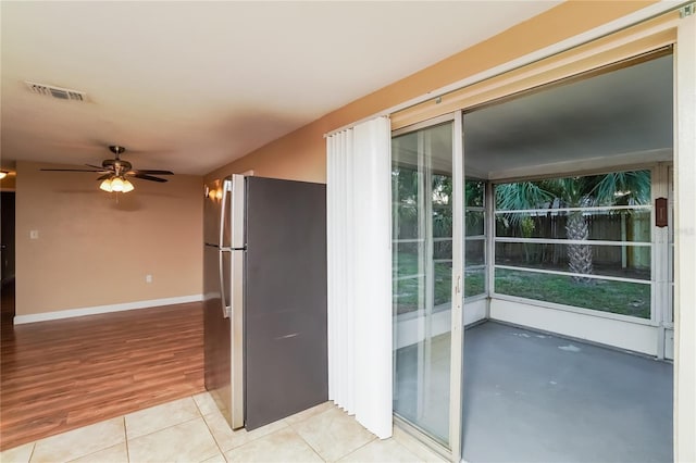 doorway with light wood-type flooring and ceiling fan