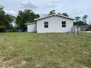 view of property exterior featuring a yard and fence