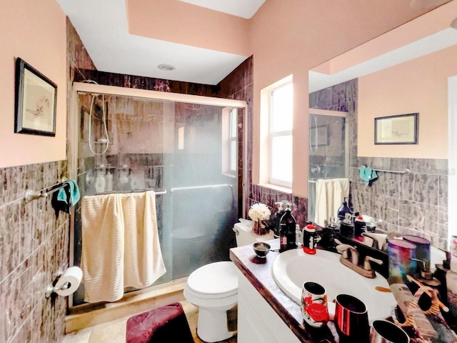 bathroom featuring a shower with door, toilet, and tile walls