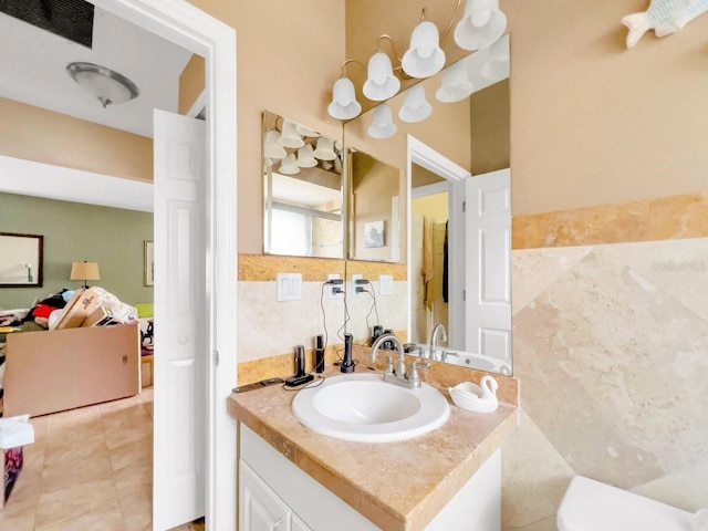 bathroom with tile patterned flooring, vanity, and tile walls