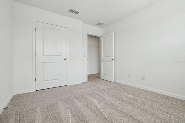 unfurnished bedroom featuring light carpet