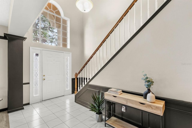 foyer entrance featuring a towering ceiling and light tile patterned floors