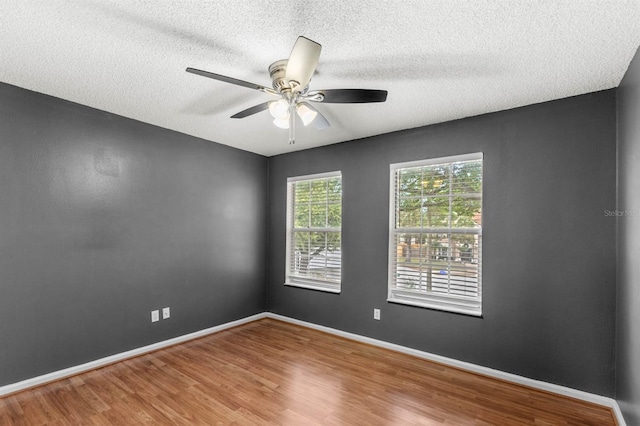 empty room with hardwood / wood-style floors, ceiling fan, and a textured ceiling