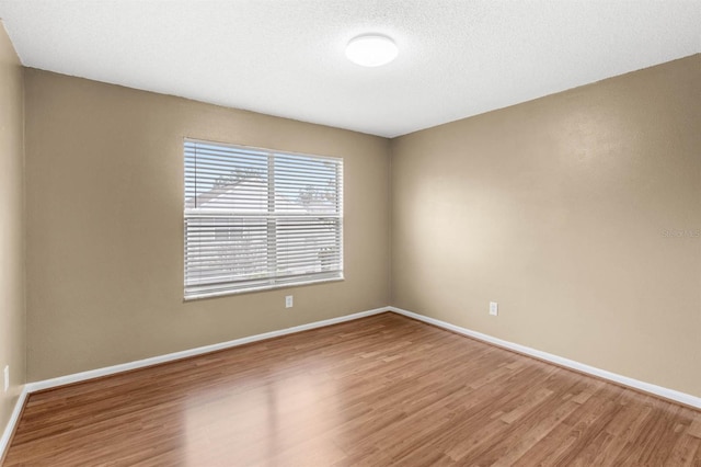 spare room with wood-type flooring and a textured ceiling