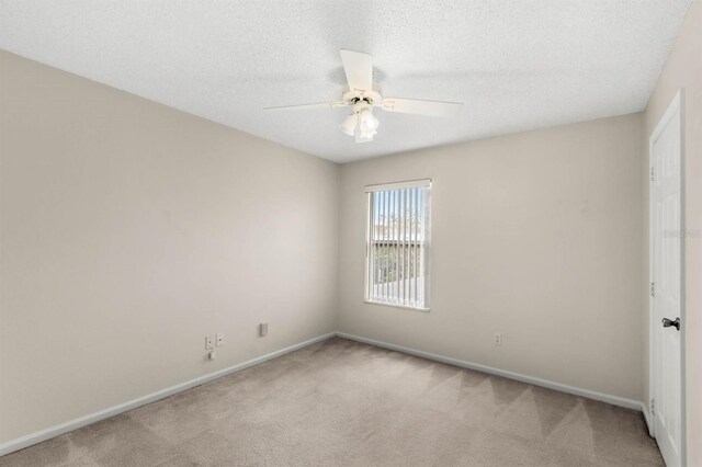 unfurnished room with a textured ceiling, ceiling fan, and light carpet