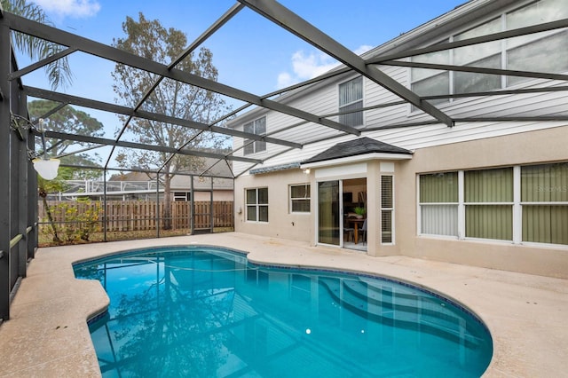 view of swimming pool featuring a patio and glass enclosure