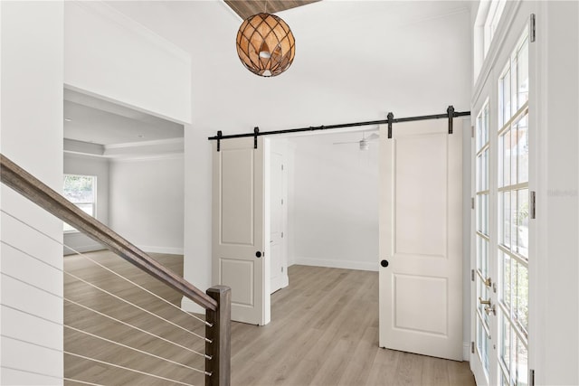 interior space featuring ornamental molding, a barn door, and hardwood / wood-style floors