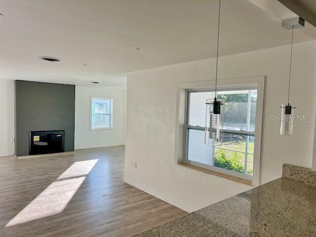 unfurnished living room with a large fireplace and hardwood / wood-style floors