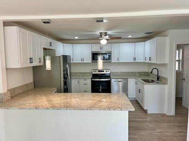 kitchen featuring kitchen peninsula, white cabinetry, and appliances with stainless steel finishes