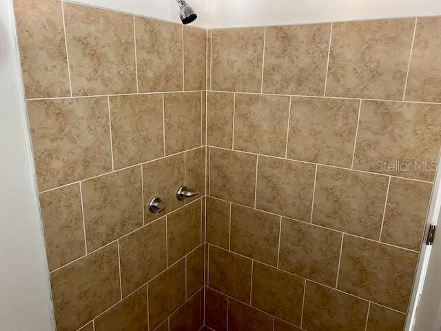 interior details featuring a tile shower