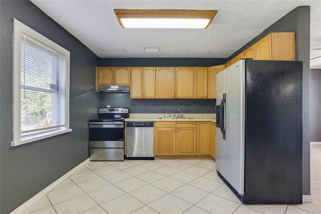 kitchen featuring light tile patterned flooring, appliances with stainless steel finishes, and sink