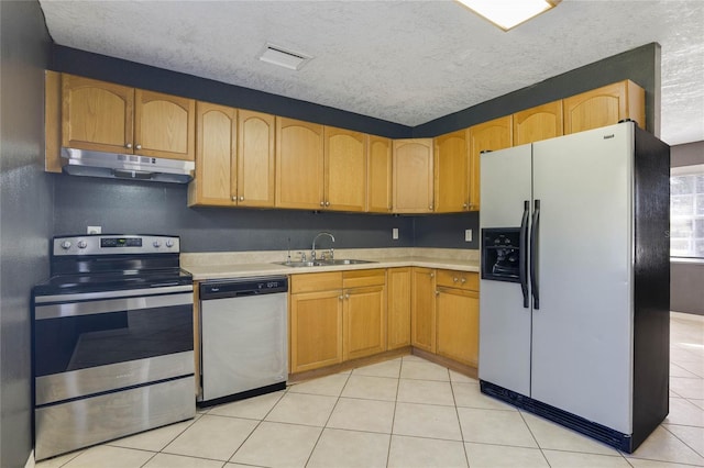 kitchen with sink, light tile patterned floors, stainless steel appliances, and a textured ceiling