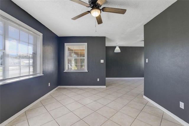 spare room with ceiling fan, a textured ceiling, and light tile patterned floors