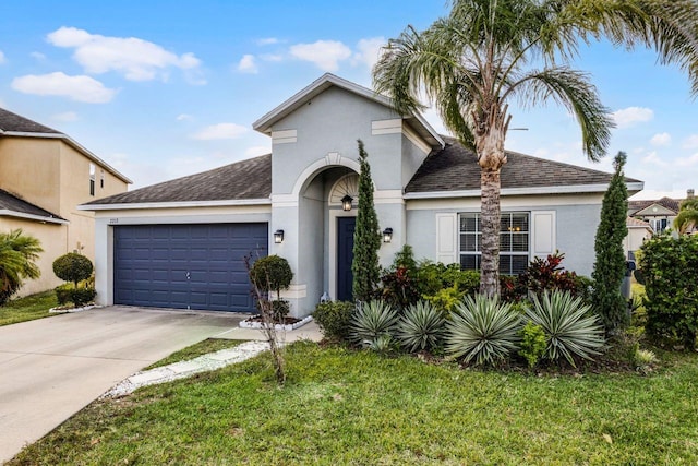 view of front of home with a garage and a front lawn