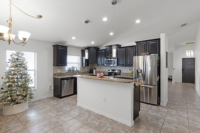 kitchen with a center island, hanging light fixtures, lofted ceiling, and appliances with stainless steel finishes