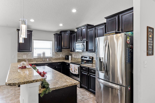 kitchen with a breakfast bar, sink, a textured ceiling, a kitchen island, and stainless steel appliances