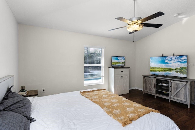 bedroom featuring dark hardwood / wood-style floors, vaulted ceiling, and ceiling fan