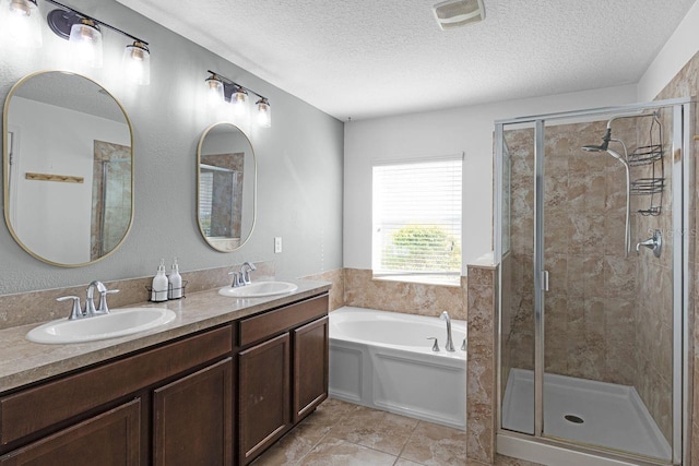 bathroom featuring tile patterned flooring, vanity, independent shower and bath, and a textured ceiling