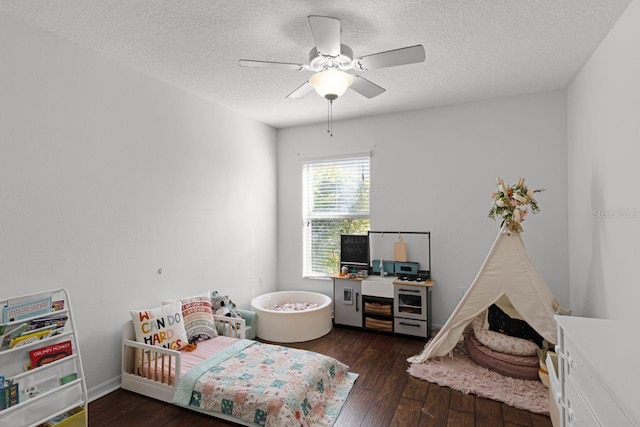 bedroom featuring ceiling fan, dark wood-type flooring, and a textured ceiling