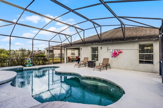 view of pool featuring glass enclosure and a patio