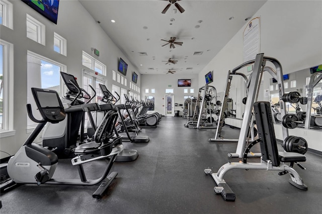 exercise room featuring ceiling fan and a towering ceiling