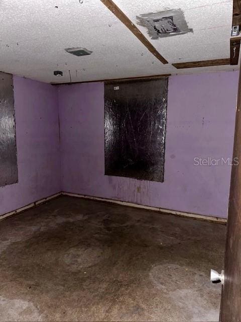 spare room with concrete flooring and a textured ceiling