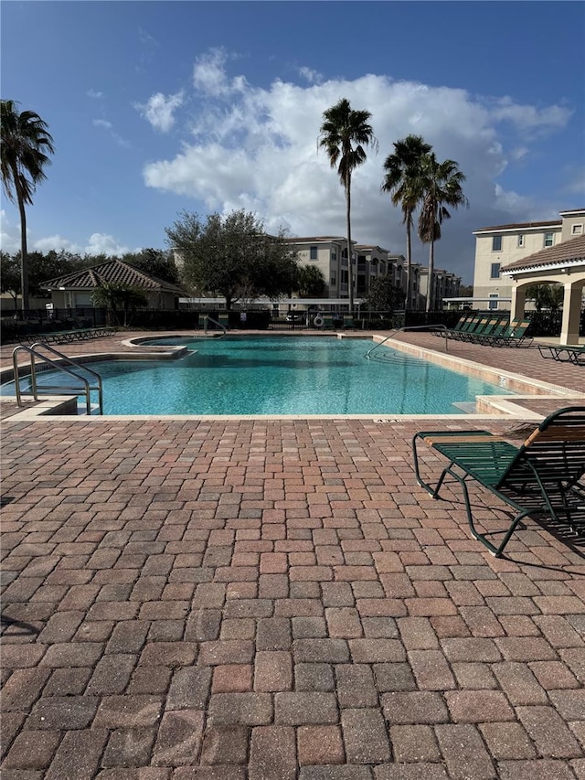 view of pool with a hot tub and a patio area