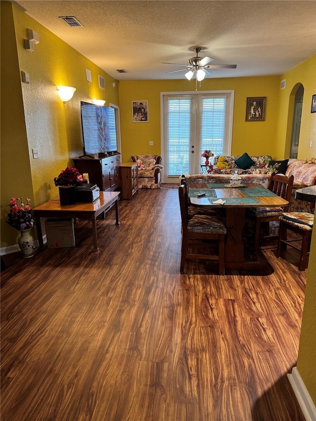 dining room featuring french doors, a textured ceiling, dark hardwood / wood-style flooring, and ceiling fan