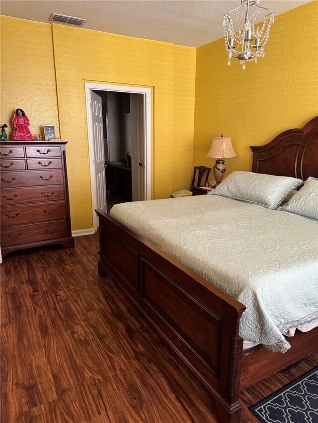 bedroom featuring dark hardwood / wood-style floors and an inviting chandelier