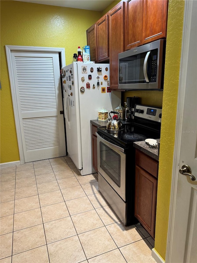 kitchen featuring stainless steel appliances and light tile patterned flooring