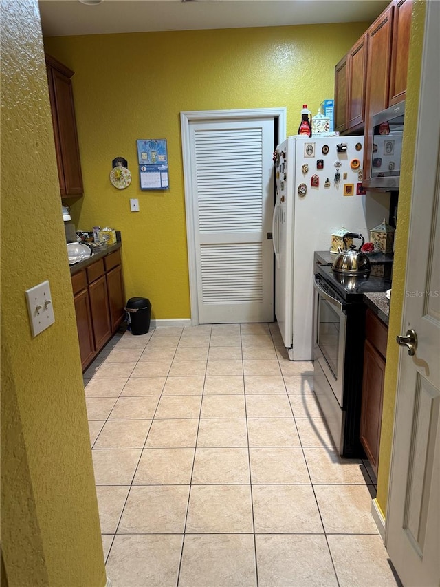 kitchen featuring stainless steel electric range oven and light tile patterned flooring