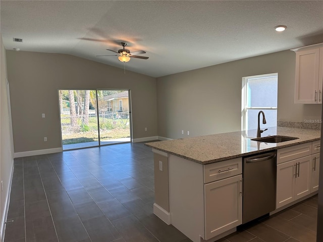 kitchen with vaulted ceiling, dishwasher, sink, white cabinets, and light stone countertops