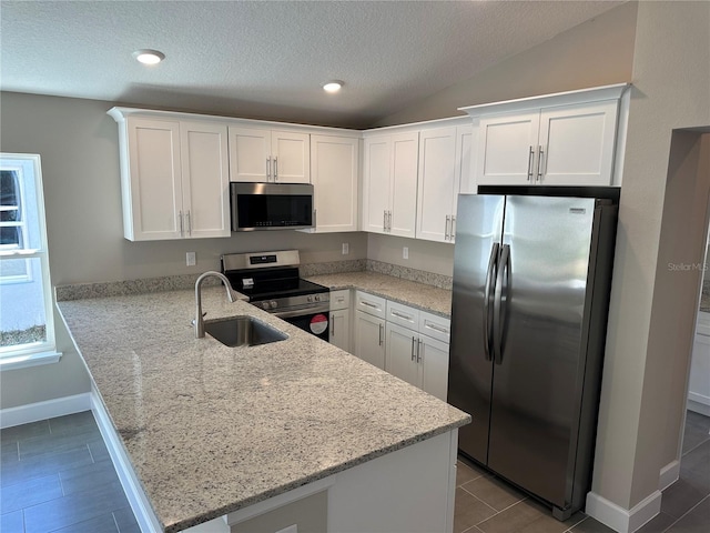 kitchen with stainless steel appliances, white cabinets, and kitchen peninsula