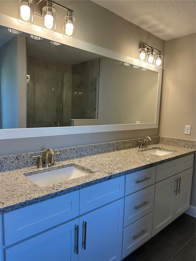 bathroom featuring tile patterned flooring, vanity, a textured ceiling, and walk in shower