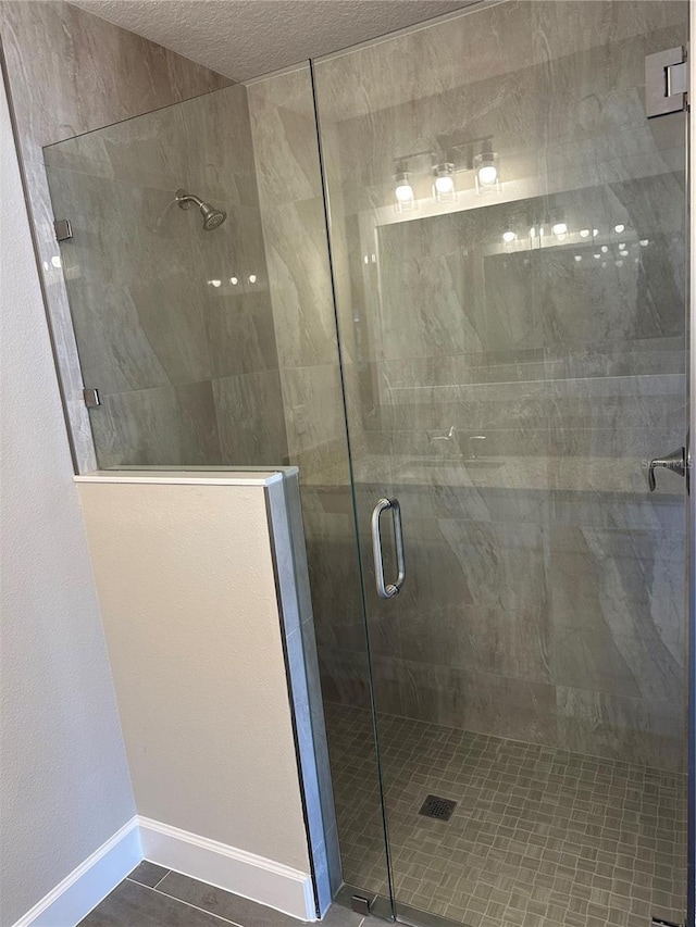 bathroom with walk in shower and a textured ceiling