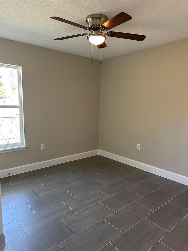 unfurnished room with ceiling fan and a textured ceiling