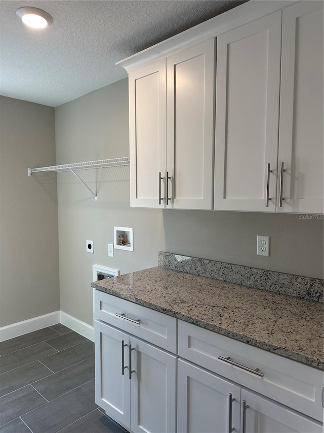 washroom with cabinets, electric dryer hookup, washer hookup, and a textured ceiling