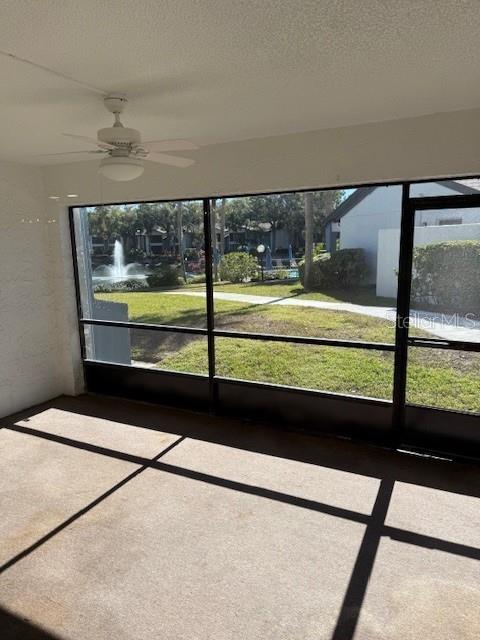 unfurnished sunroom with ceiling fan