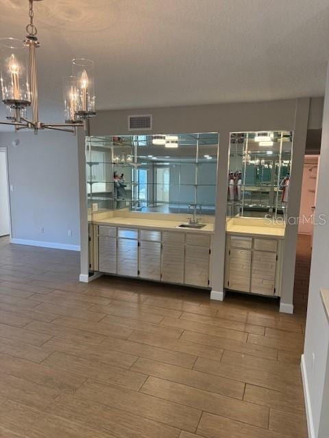 kitchen featuring light hardwood / wood-style floors, sink, hanging light fixtures, and a notable chandelier