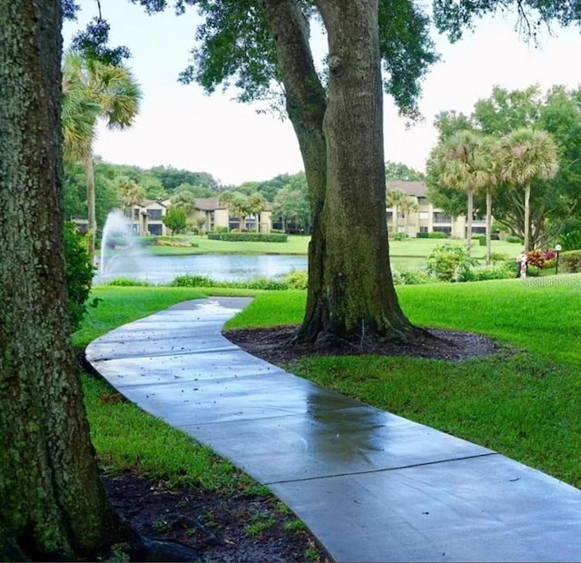 surrounding community featuring a lawn and a water view