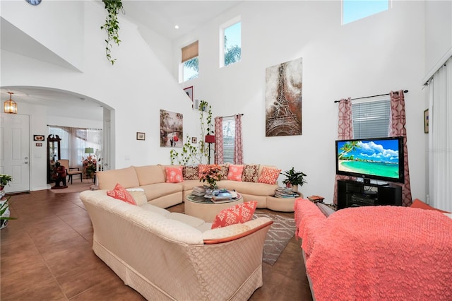 tiled living room featuring a high ceiling and plenty of natural light