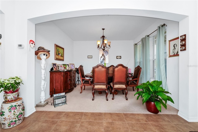 dining space with a notable chandelier and light tile patterned flooring