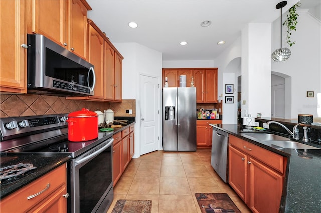 kitchen with decorative backsplash, stainless steel appliances, sink, light tile patterned floors, and hanging light fixtures