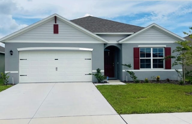 ranch-style house featuring a garage and a front lawn