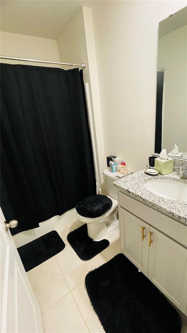 bathroom featuring toilet, vanity, tile patterned floors, and curtained shower