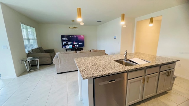 kitchen featuring light stone countertops, sink, stainless steel dishwasher, and decorative light fixtures